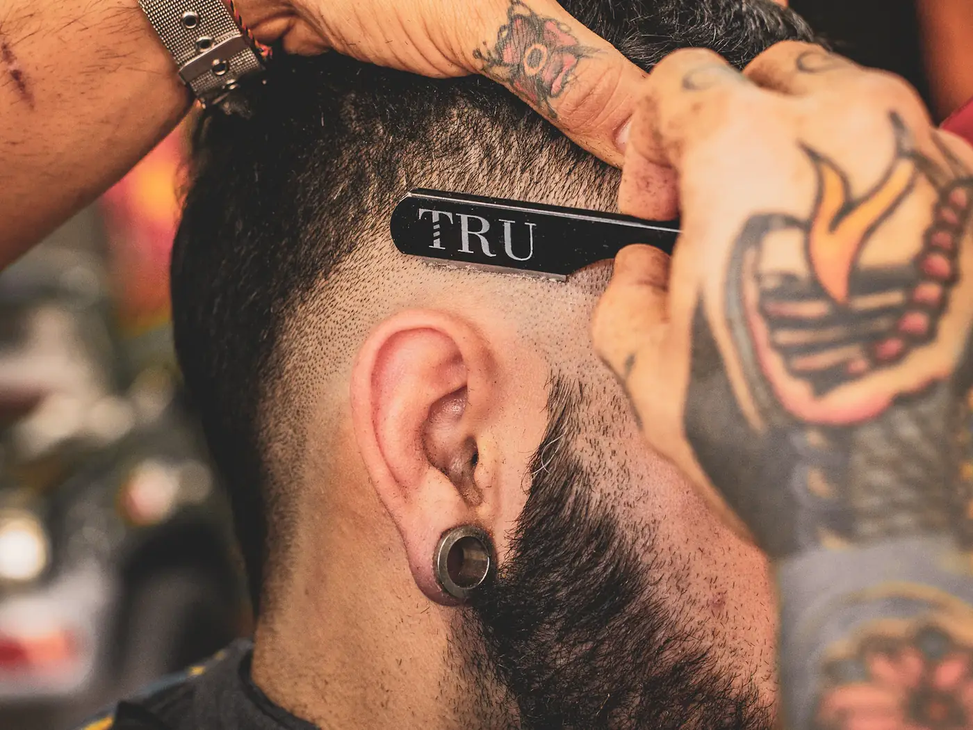 Barbero perfilando un corte con navaja