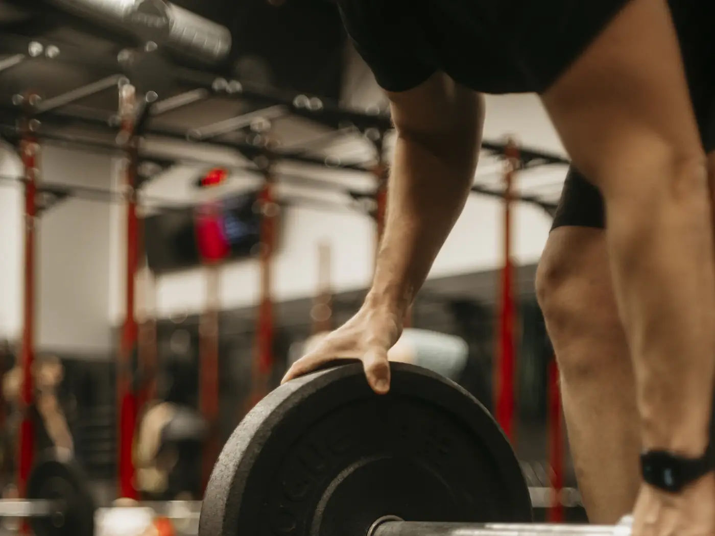 Persona levantando una barra en el gimnasio
